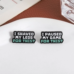 Enamel lapel pins featuring I Shaved My Legs and I Paused My Game funny quotes