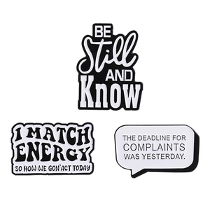 Minimalist black and white enamel pins set with text slogans on a white background