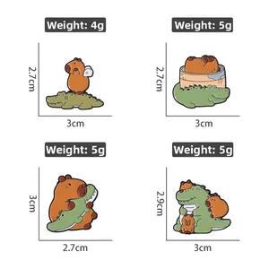 Détail des épinglettes en émail capybara et crocodile pour décoration de sac