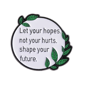 Round white enamel pin with inspirational quote and green leaf design for clothing