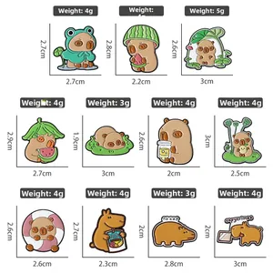 Detailed grid of cartoon capybara enamel pins with frog and watermelon designs