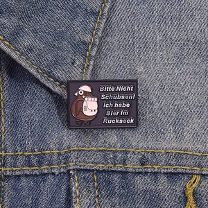 Funny purple enamel pin with kiwi bird and German text on denim jacket