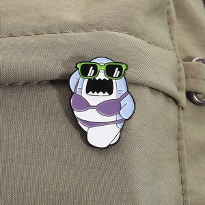 Detail of cartoon shark enamel pin with sunglasses and bikini on canvas fabric