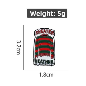 Détail du pin's en émail pull rayé rouge et vert avec texte Sweater Weather gravé
