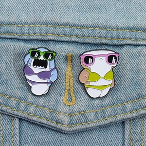 Détail de pins émaillés requins en bikini épinglés sur une poche de veste en jean bleu