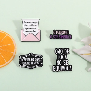 Lot de quatre broches en émail coloré avec texte espagnol sur fond vert clair