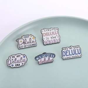 Lot de 5 broches en émail Delulu aux tons pastel avec slogans humoristiques dans un plat épuré