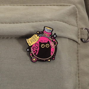 Detail of a black cat in a potion bottle enamel pin attached to a canvas backpack pocket