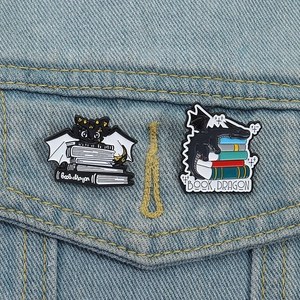 Lot de pins émaillés Book Dragon de dessin animé sur fond de tissu en denim bleu