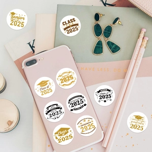 Close-up of Class of 2025 graduation stickers on a pink phone and notebook