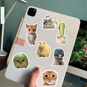 Close-up of funny cat meme stickers on a white tablet with realistic home office setup