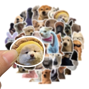 Close-up of hand holding a waterproof cartoon dog sticker showing print details