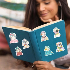 Detail of colorful animal stickers with polka dot hats on a blue notebook cover