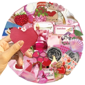 Close-up of hand holding a red heart-shaped sticker from the Y2K pink girlhood sticker set