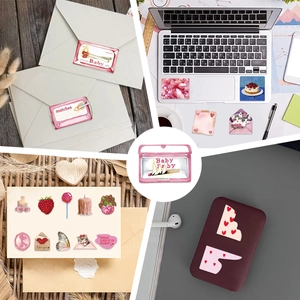 Detail view of Y2K girlhood aesthetic stickers on laptop and envelope in pink tones