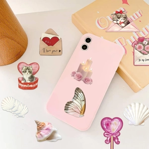 Flat lay of pink Y2K girlhood stickers with kittens and hearts on a cream desk