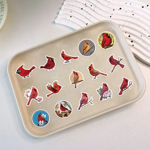 Detailed view of cardinal bird stickers featuring flying and perched poses on a tray
