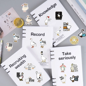 Close-up of waterproof cartoon goose stickers on a notebook with decorative props
