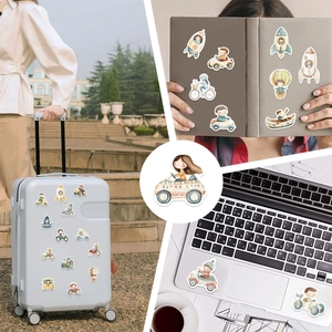 Close-up of waterproof cartoon vehicle stickers on luggage and laptops for DIY decoration