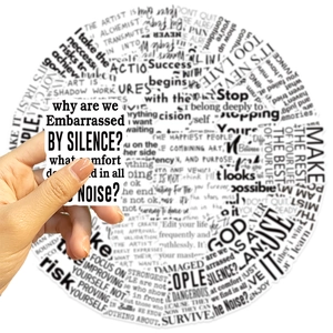 Hand holding a waterproof black and white quote sticker with artistic philosophy text