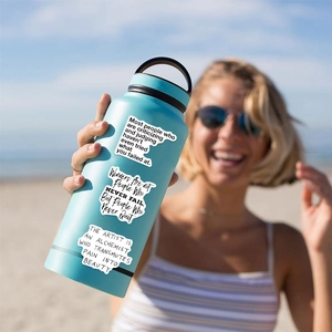 Close-up of light blue stainless steel water bottle with motivational quote stickers