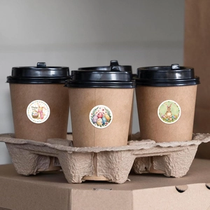 Easter rabbit sticker on a brown paper cup with festive patterns and Happy Easter text