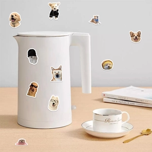 Dettaglio di adesivi decorativi con cani golden retriever su bollitore e scrivania
