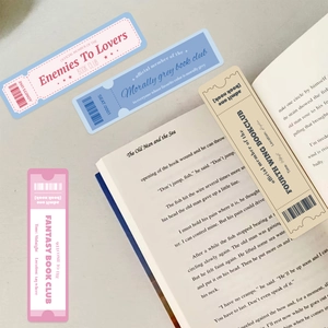 Book Lovers Club ticket-style bookmarks set on vintage open book pages on a wood desk