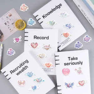 Detailed view of laser rose heart stickers with pearlescent finish on a white notebook