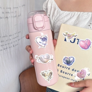 Y2K aesthetic heart and rose stickers applied on a pink water bottle and yellow book