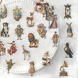Dettaglio di adesivi vintage in stile vittoriano con animali e fiori su piatto bianco