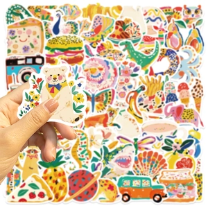 Gros plan d'une main tenant un autocollant d'ours parmi des illustrations de nourriture