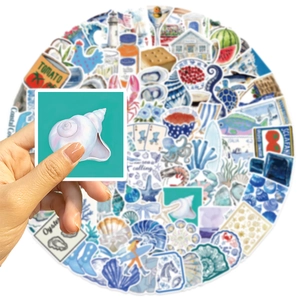 Close-up showing various blue coastal aesthetic stickers for guitar and laptop decoration