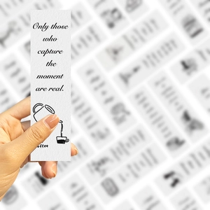 Minimalist paper bookmark featuring a black cursive quote and hand-drawn coffee pot