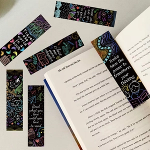 Gros plan de 6 marque-pages artistiques style craie avec citations sur un livre ouvert