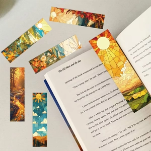 Marcadores artísticos de vitrales con paisajes sobre una página de libro abierto
