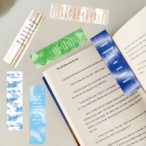 Artistic paper bookmarks featuring literary quotes and watercolor patterns on an open book