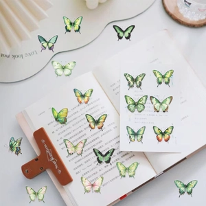 Vue détaillée d'autocollants papillons verts sur un livre pour scrapbooking créatif