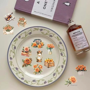 Dettaglio di adesivi vintage con rose arancioni e illustrazioni di violino