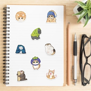 Detail of cute watercolor cat stickers on a notebook with stationery and succulents