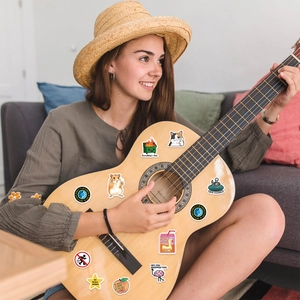 Detailed view of fun cartoon cat stickers applied to a guitar for personalized decoration