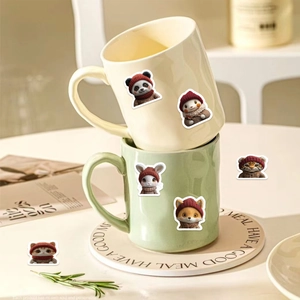 Close-up of cute cartoon animal stickers on ceramic mugs for creative DIY decoration