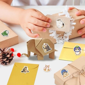 Roll of cartoon cat stickers being used to decorate gift boxes and envelopes