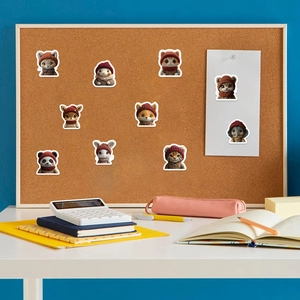 Close-up of cute cartoon cat and fox stickers with red hats on a memo board
