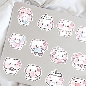 Dettaglio di simpatici adesivi di gatti a fumetti decorati su un laptop d'argento con stile DIY