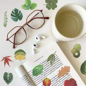 Flat lay of realistic PET plant stickers with leaves on white desk with accessories
