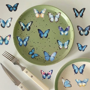 Détail d'autocollants papillons colorés étanches décorant une assiette en céramique