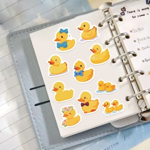 Close-up of cute cartoon yellow duck stickers on a notebook for DIY scrapbooking