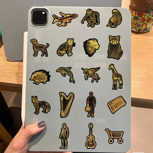 Primo piano di adesivi dorati con animali applicati su una custodia grigia per tablet