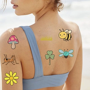 Detail of colorful cartoon insect temporary tattoos featuring bees and mushrooms on skin